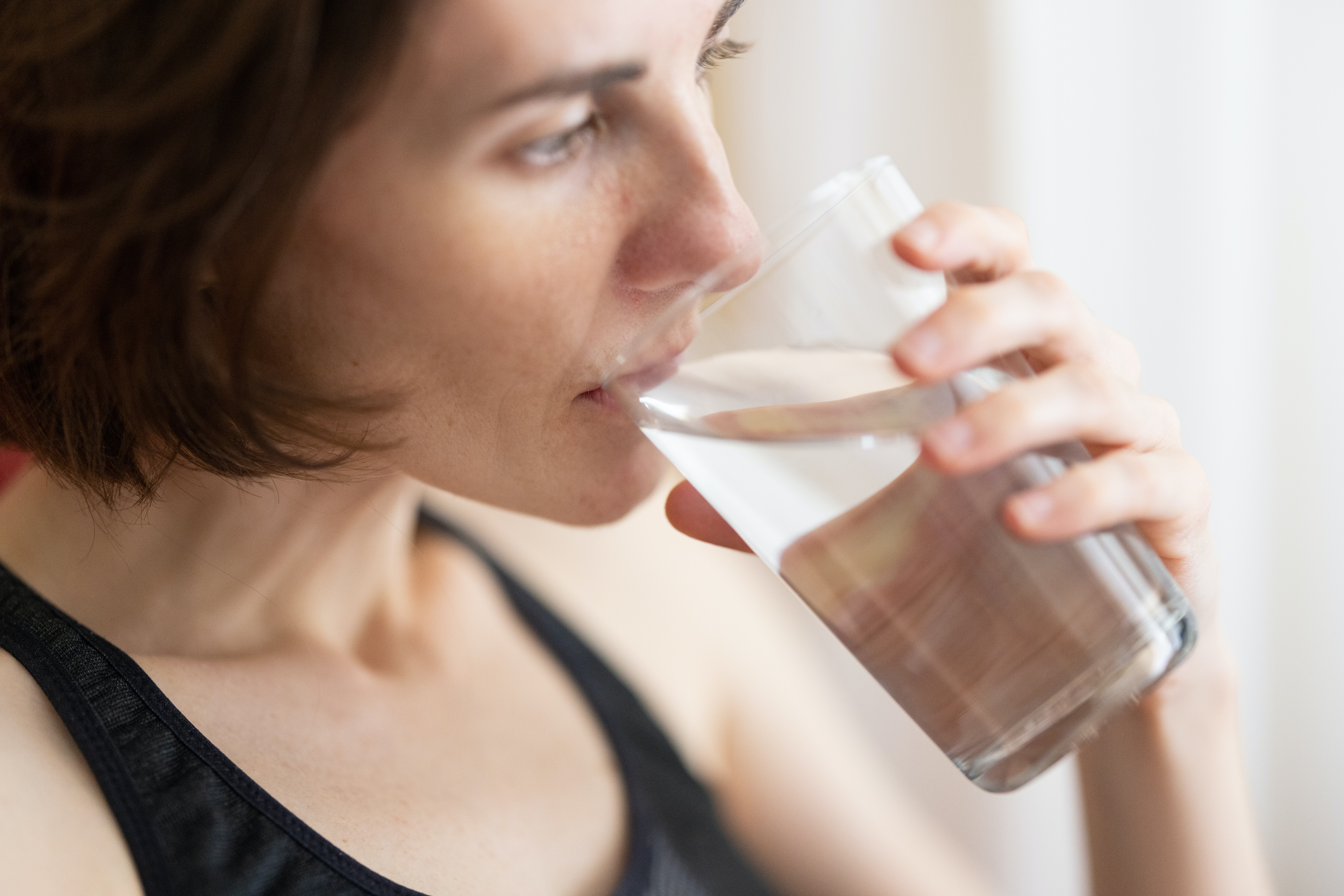 Dark haired woman drinking water